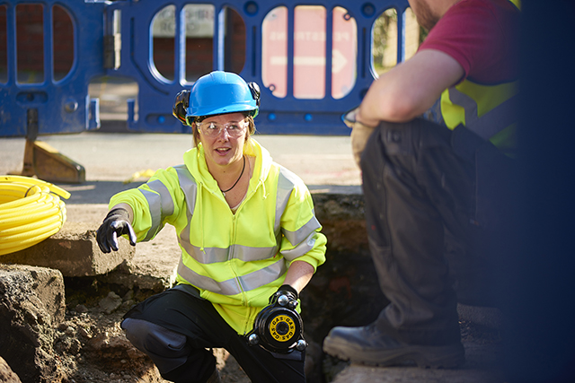 a female gas engineer holds a new gas valve as she and a colleague prepare to replace the old pipework in a residential uk street .